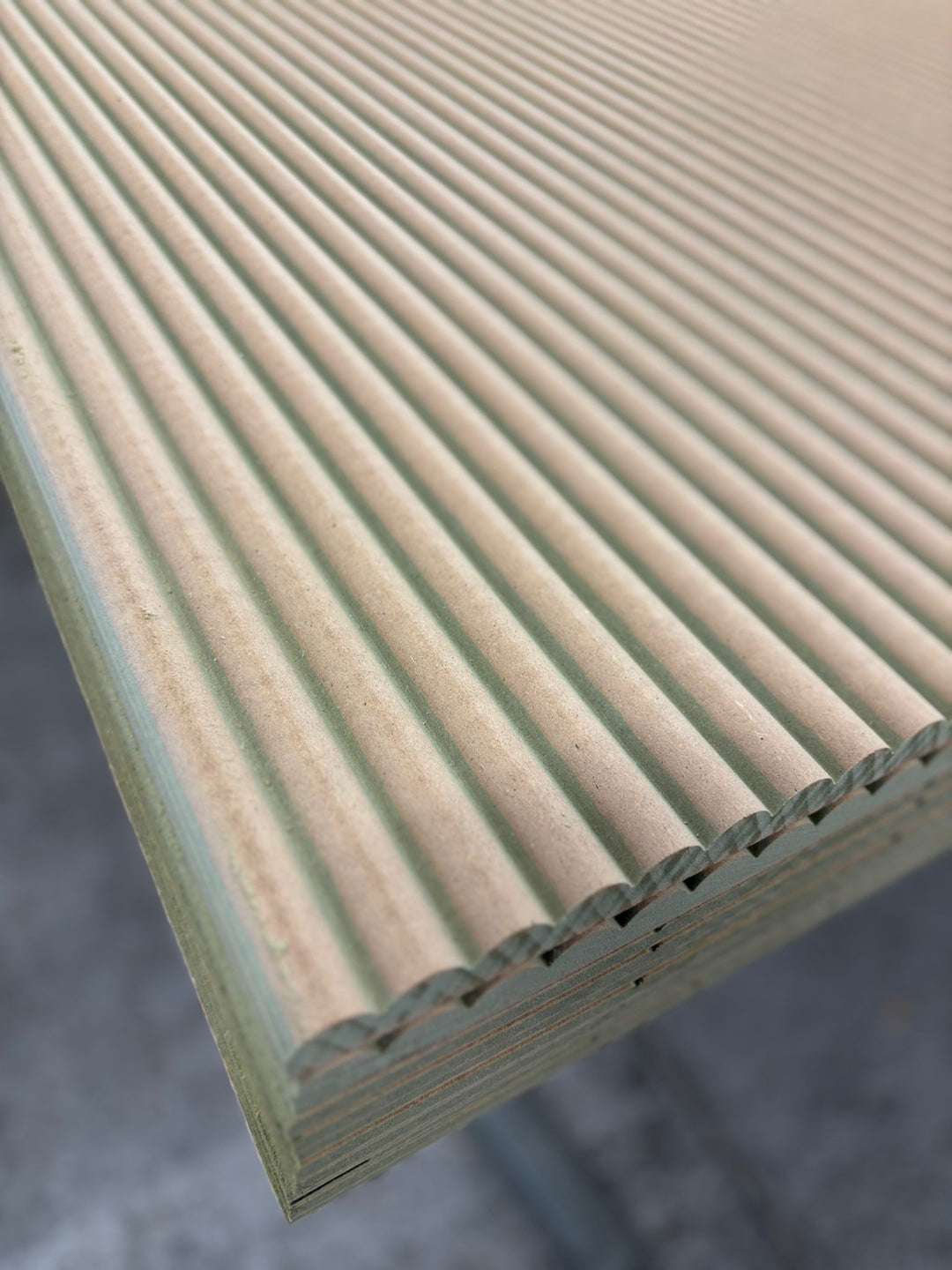Angled view of ribbed MDF panelling sheets showing parallel rounded ribs across the surface